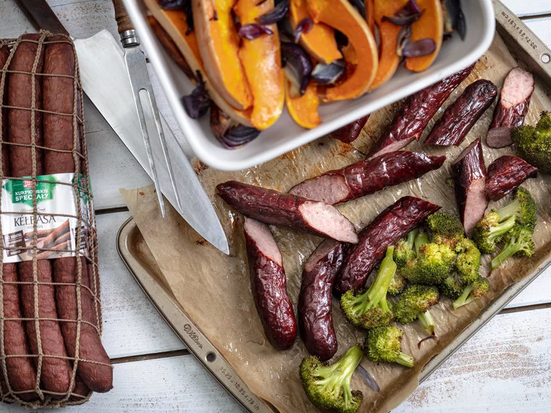 Przepis na rozgrzewający i sycący, jesienny obiad – pieczona kiełbasa z dynią, brokułami, czosnkiem i czerwoną cebulą - zdjęcie