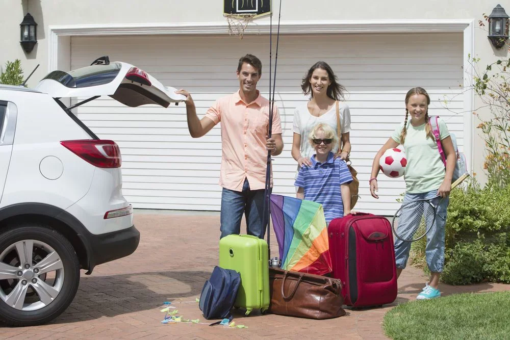 Bezpieczne mieszkanie na majówkę, rodzina wyjeżdzająca na wakacje pakująca samochód