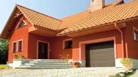 Jednolita kolorystyka bramy garażowej, okien i drzwi pozwala otrzymać spójną kompozycję fasadową utrzymaną w klasycznej estetyce Fot. WIŚNIOWSKI