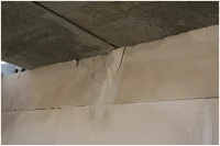 Przykład uszkodzeń ściany z bloczków betonu komórkowego pod wpływem bezpośredniego oparcia stropu