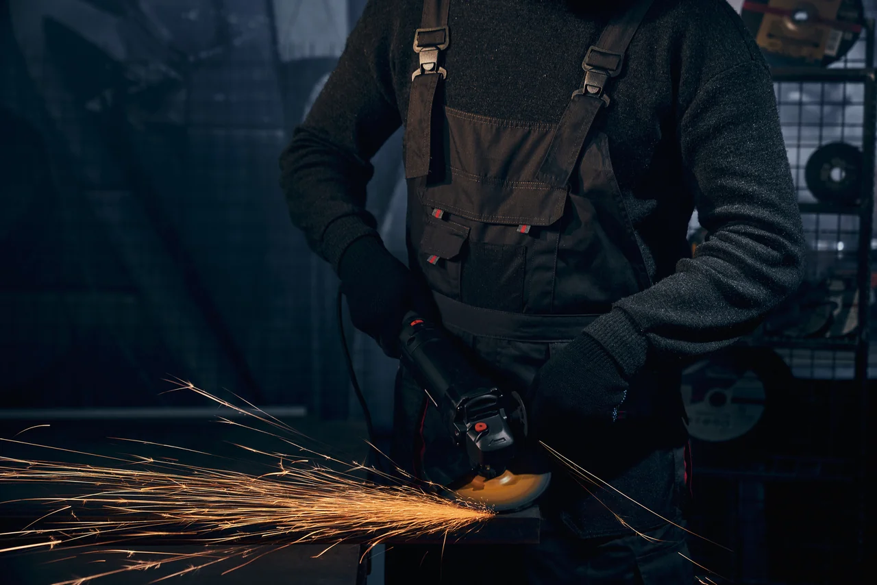 man black suit polishing metal with angle grinder