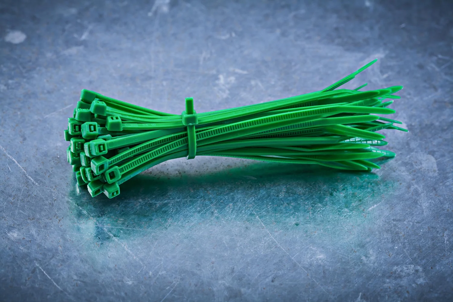 green plastic selflocking cable ties on metallic background construction