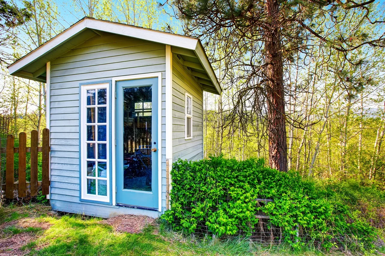 Drewniany domek ogrodowy pomalowany na kolor błękitny