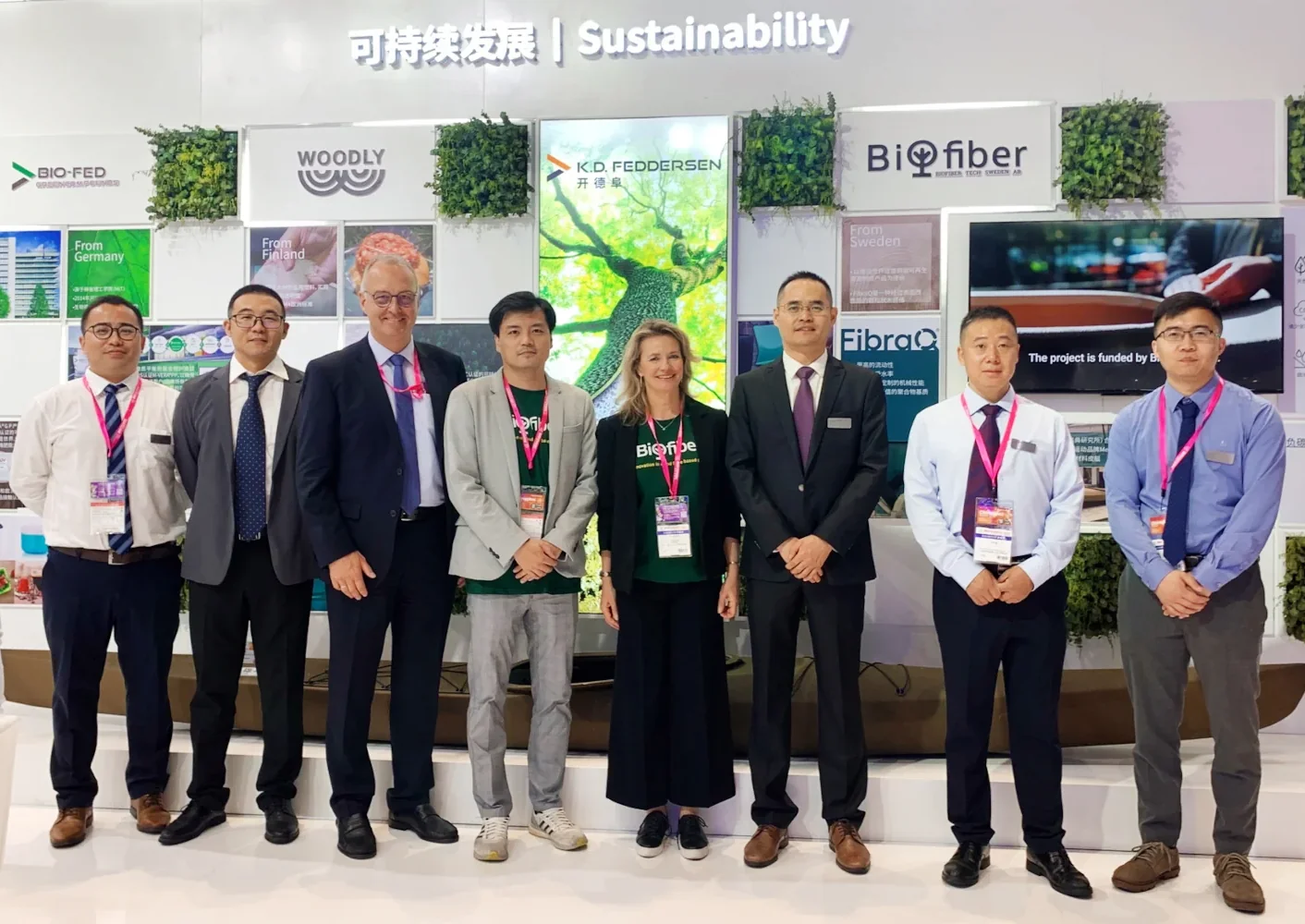 Pia Ingvallsén (centre) and Sam Zhuo (left) from Biofiber Tech Sweden AB with employees from K.D.F. Distribution (Shanghai) Co., Ltd. at Chinaplas 2023. The 3D-printed full-size kayak made of wood fibers and recycled plastic compounds is in the background.